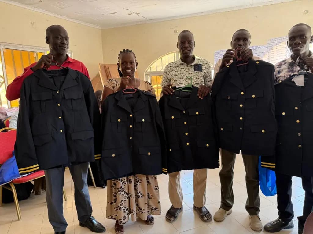 Turkana County officials distribute ceremonial uniforms to village administrators during an official event
