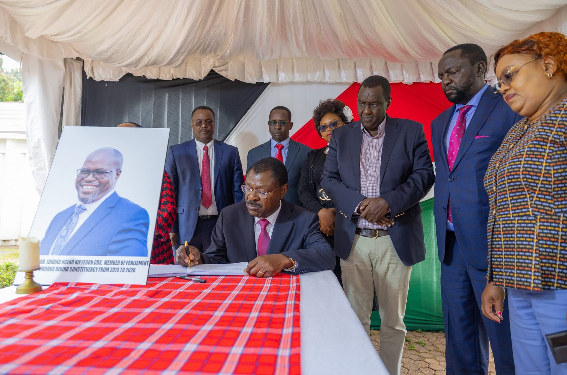 National Assembly Speaker Moses Wetang'ula (seated) signing the condolence book at the home of former Emurua Dikirr MP Johana Ng'eno